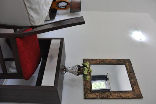 a mirror on a wall next to a table with a lamp at Villa Bella Boutique Hotel in Kavadarci