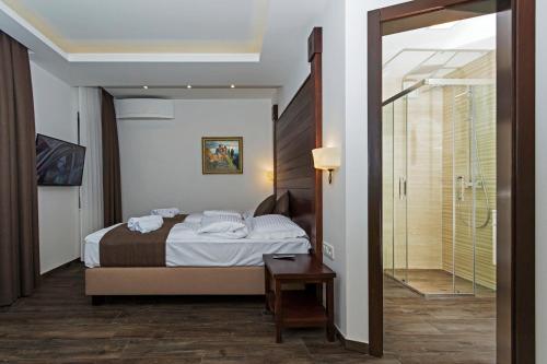 a bedroom with a bed and a walk in shower at Villa Sofija in Ohrid