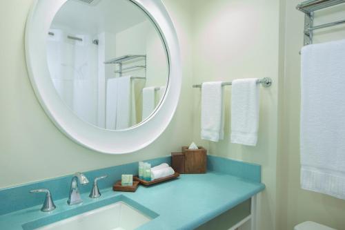 a bathroom with a sink and a mirror at Coconut Waikiki Hotel in Honolulu