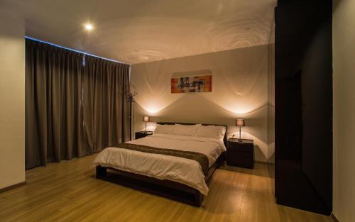 a bedroom with a large bed with two lamps at Luxfort 118 Service Suites in George Town