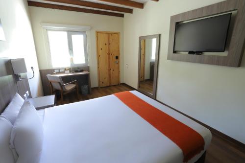 a hotel room with a bed and a flat screen tv at Casa Andina Standard Chincha in Chincha Alta