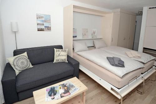 Habitación pequeña con cama y sofá en Studio 25 Davos Platz en Davos