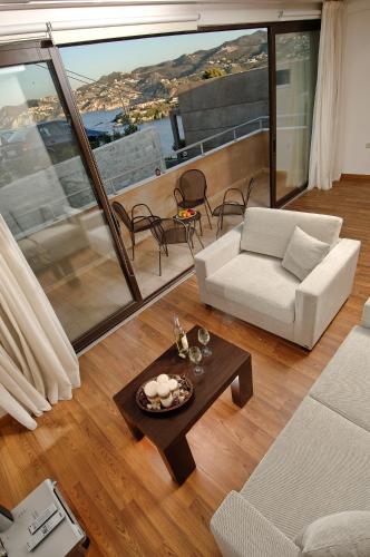 a living room with a couch and a table at Eva Mare Hotel & Suites - Adults only in Agia Pelagia