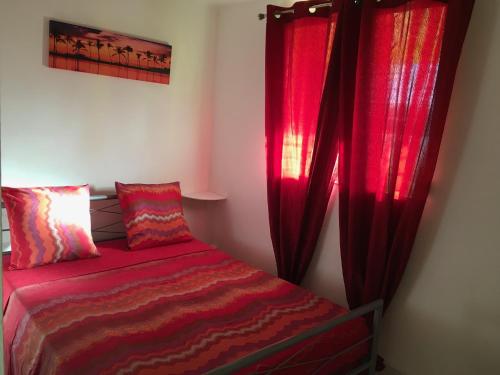 a bedroom with red curtains and a bed at Amory in Fort-de-France