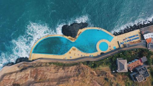 an aerial view of a resort on the edge of the ocean at Jaca Hostel Porto da Cruz in Porto da Cruz