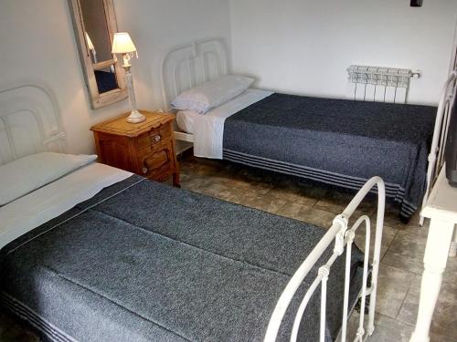 a bedroom with two beds and a night stand and a mirror at DTO SERRANO in Tandil