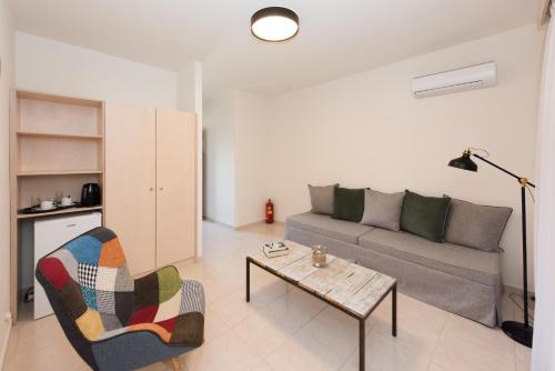 a living room with a couch and a table at Eva Mare Hotel & Suites - Adults only in Agia Pelagia