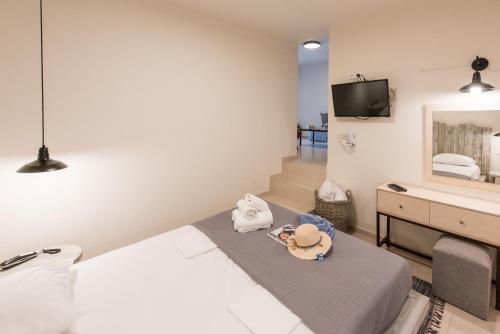 a hotel room with a bed and a television at Eva Mare Hotel & Suites - Adults only in Agia Pelagia