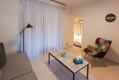 a living room with a couch and a table and a chair at Eva Mare Hotel & Suites - Adults only in Agia Pelagia