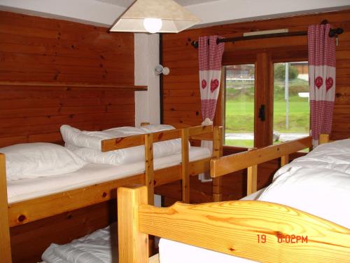 a room with three bunk beds and a window at Appartement les Carroz d'Arraches in Les Carroz d'Araches