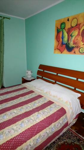 Casa Stellone في Villastellone: غرفة نوم بسرير مع لوحة على الحائط
