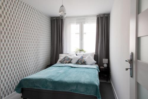 a small bedroom with a bed with a window at Legnica Apartament 52m2 Delux 1 in Legnica