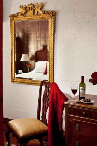 a bedroom with a mirror and a chair and a bottle of wine at American Guest House, a Washington DC Bed and Breakfast in Washington