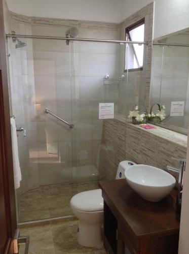 a bathroom with a toilet and a glass shower at HOTEL LA POSADA DEL ZAGUÁN in El Retiro