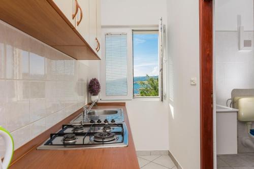 a kitchen with a stove top and a window at Apartments Hidden Beach Gem in Pag