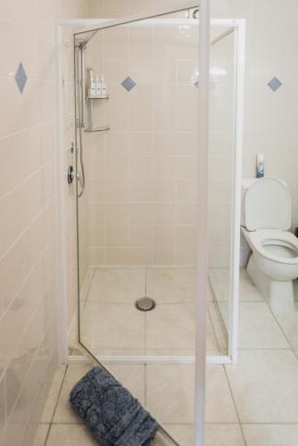 a shower with a glass door in a bathroom at Absolute Bliss Apartments in Paihia