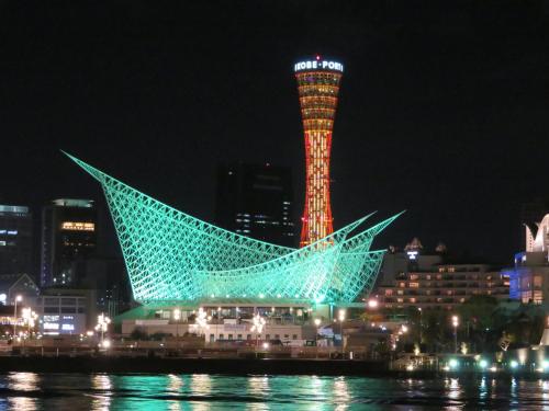a building with a tower lit up at night at Hotel Wing International Kobe - Shinnagata Ekimae in Kobe