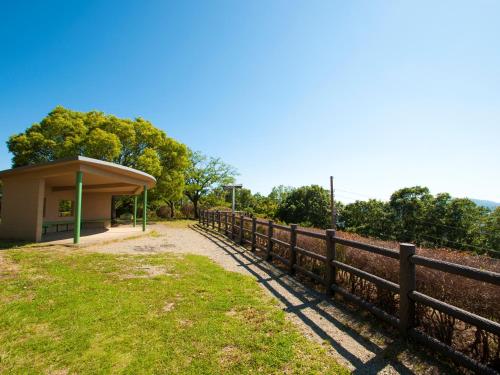 a bus stop next to a wooden fence at Hotel Wing International Kobe - Shinnagata Ekimae in Kobe