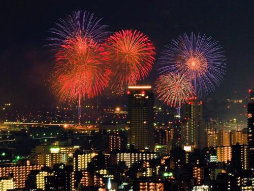a group of fireworks in the sky over a city at Hotel Wing International Kobe - Shinnagata Ekimae in Kobe