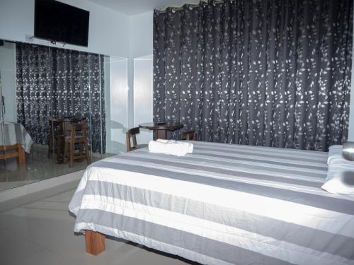 ein Schlafzimmer mit einem Bett mit einer schwarz-weißen Decke in der Unterkunft Hostal Sueños in Lima