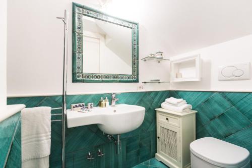a bathroom with a sink and a toilet and a mirror at Residenza San Luca Praiano in Praiano