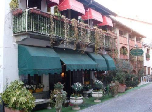 a building with a balcony with potted plants on it at Una Franca Camere Di Charme in Biella