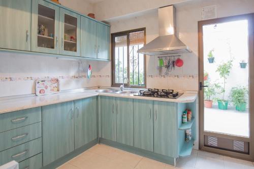 kuchnia z niebieskimi szafkami, umywalką i oknem w obiekcie Apartamento Albaycin Granada w Grenadzie