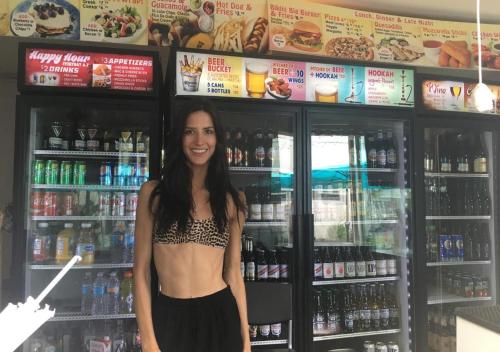 una donna è in piedi davanti a un frigorifero di Bikini Hostel, Cafe & Beer Garden a Miami Beach