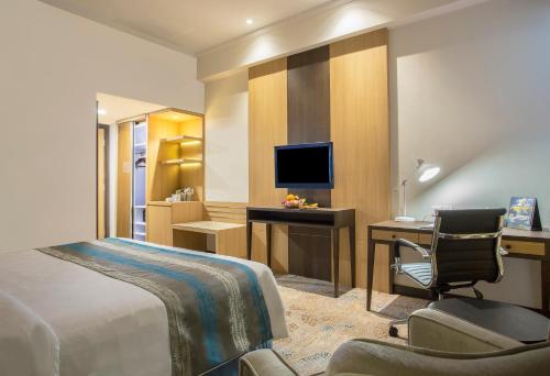a hotel room with a bed and a desk and a computer at Swiss-Belhotel Papua in Jayapura