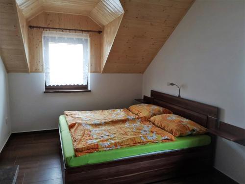 a bedroom with a bed with a wooden headboard and a window at Apartmány Nad řekou in Svoboda nad Úpou