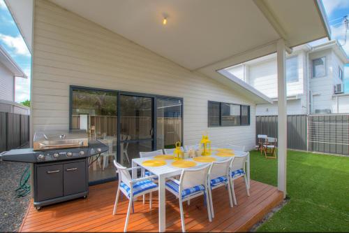 a patio with a table and chairs and a grill at A Little Luxury in Town in Dunsborough