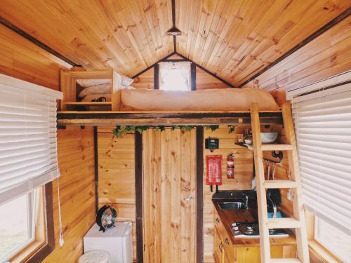 a bedroom with a bunk bed in a tree house at Hilltop Tiny House by Tiny Away in Tallarook
