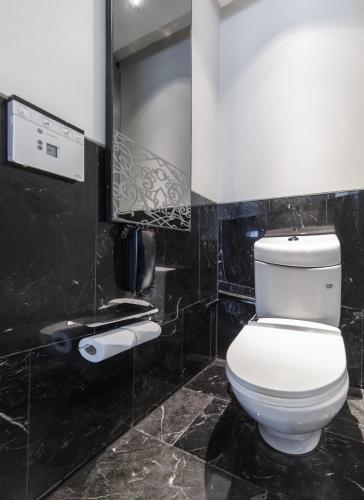 a bathroom with a white toilet and a mirror at Le Meridien Bangkok in Bangkok