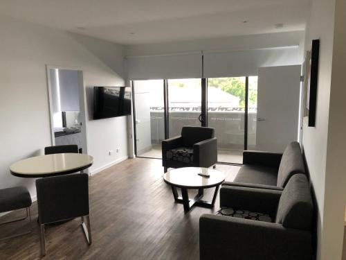 a living room with a couch and chairs and a table at Quattro On Young in Newcastle
