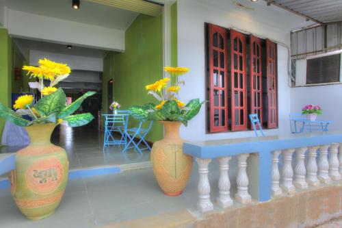 two vases with flowers in them sitting on a wall at Sams ChiangKhan in Chiang Khan