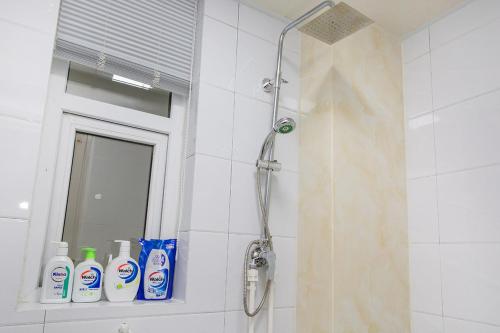 a shower in a bathroom with a mirror and some cleaning products at Henan Kaifeng·Henan University· Locals Apartment 00139770 in Kaifeng