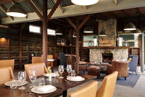 a dining room with a table and a fireplace at Spicers Hidden Vale in Grandchester