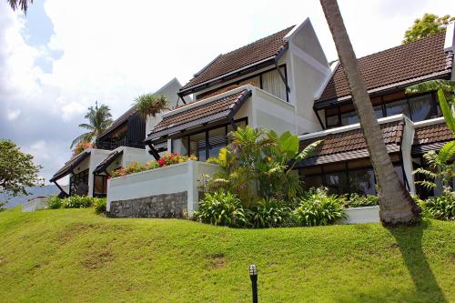 a house on a hill with a palm tree at Kamala Beach Estate Resort - SHA Extra Plus in Kamala Beach