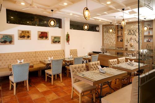 un restaurante comedor con mesas y sillas en Ahuja Residency DLF Phase 2, en Gurgaon
