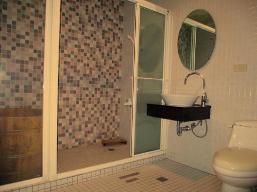 a bathroom with a shower with a toilet and a sink at 欣悅商務旅店 in Toufen