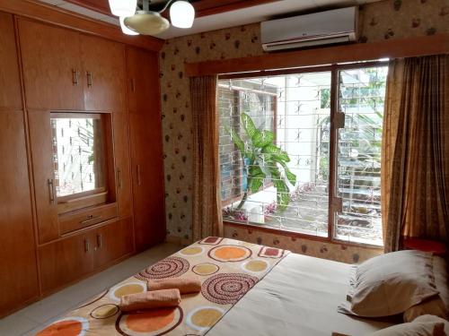 a bedroom with a bed and a large window at GIO Guesthouse Bogor in Bogor