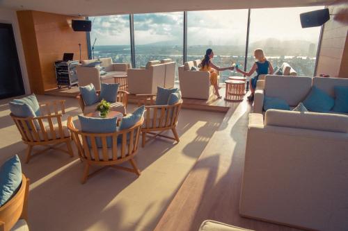 two women standing in a room with chairs and tables at TMS Hotel Da Nang Beach in Da Nang