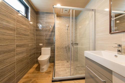 een badkamer met een douche, een toilet en een wastafel bij Tiangong Super Inn homestay in Hengchun