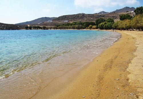 a beach with blue water and mountains in the background at Serifos Palace in Livadakia