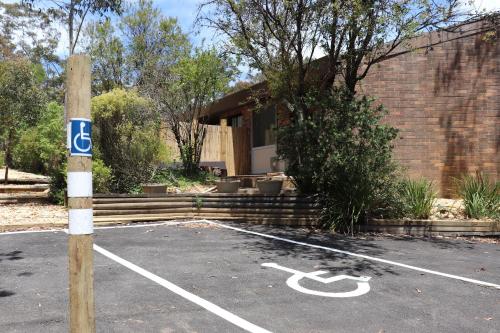 a parking lot with a handicapped sign in front of a house at Sinofield Edu-Retreat in Leura