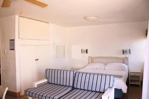 a bedroom with a bed and a striped couch at Kaliva 595 in Langebaan