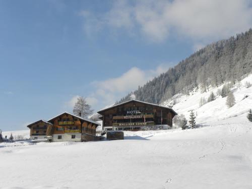a lodge in the snow in front of a mountain at Hotel Restaurant Walliser Sonne in Reckingen - Gluringen