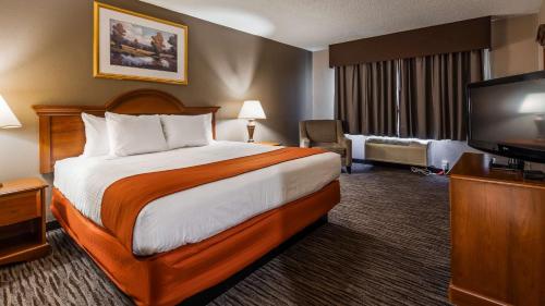 a hotel room with a bed and a flat screen tv at Best Western Gateway Adirondack Inn in Utica