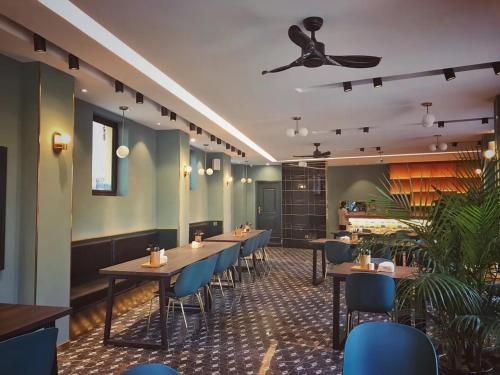 a restaurant with tables and chairs and a ceiling fan at Moon and Chalice Boutique Hotel in Kunming