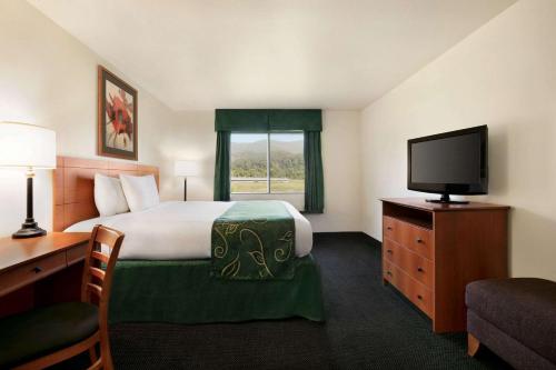 a hotel room with a bed and a flat screen tv at Travelodge by Wyndham Low Moor Near Covington in Low Moor